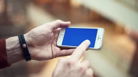 Man hands using telephone with blue screen in shopping mall Stock Footage 82989720