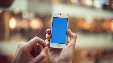 Man hands using telephone with blue screen in shopping center Stock Footage 82990107