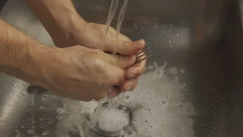 Man hands wash fork in the sink on a sunny day lifestyle Stock Footage 233103583