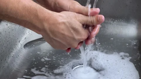 Man hands wash fork in the sink on a sunny day lifestyle Stock Footage 233463829