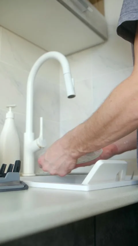 Man hands washing dishes in kitchen sink Video stock 337831065