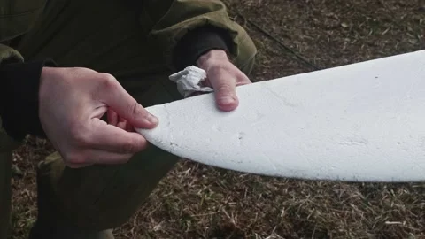 Man hands who repairs drone wing. Man glues a piece of foam plastic to wing. Stock Footage 168236879