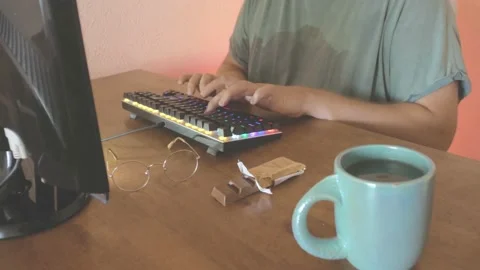 Man hands works at the computer and green mug chocolate bar and glasses Stock Footage 134154334