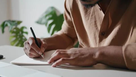 Man hands writing notebook closeup. Unrecognizable guy making notes at home Stock Photos