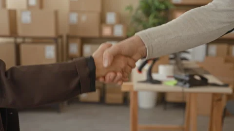 Man handshake with visible hands over stacked parcel boxes in warehouse shi.. Video stock 339241201