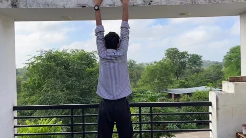 Man Hanging from Bar for Strength and Balance Training 스톡 동영상 320285573
