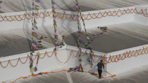 Man hanging chains of marigold rosaries on the wall of Boudha stupa. Stock-Footage 241736096