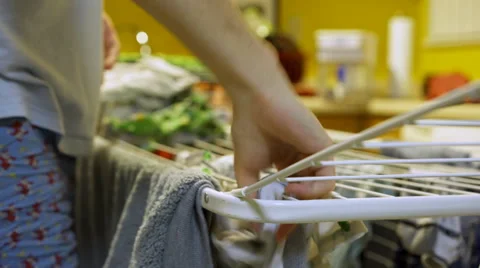 Man hanging clothes on drying rack standing in kitchen 4k Stock-Footage 60587622