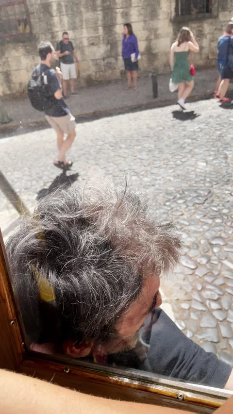 Man Hanging Dangerously Outside Moving Tram Through Historic Streets of Lisbon Видео 340881479