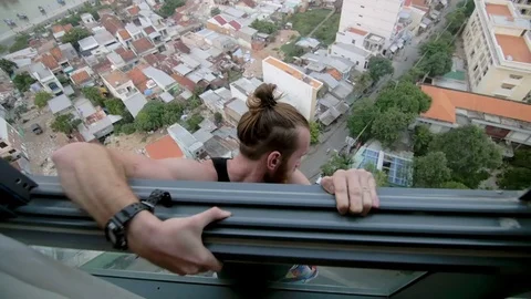 Man hanging outside the window and climbed back Stock Footage 73353425