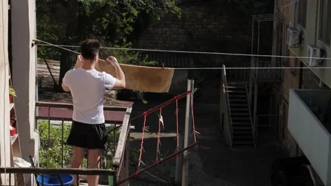 Man hanging things on the balcony Stock Footage 194514672