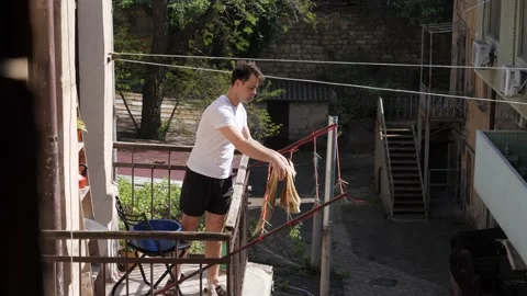 Man hanging things on the balcony Video stock 194742631