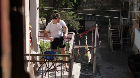 Man hanging things on the balcony Stock Footage 195052560