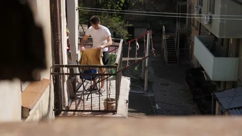 Man hanging things on the balcony Video stock 195053145