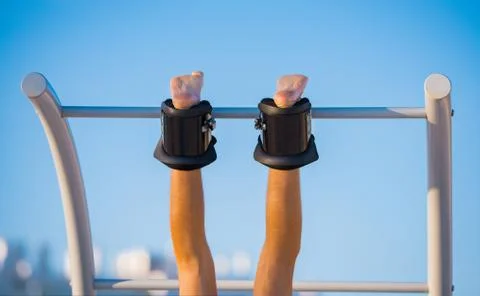 Man hanging upside down on the horizontal bar in anti gravity or inversion boots Stock Photos