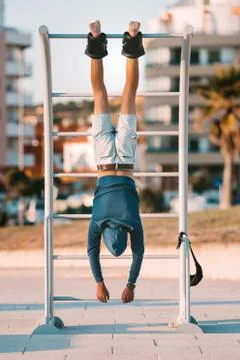 Man hanging upside down on the horizontal bar in anti gravity or inversion boots Stock Photos