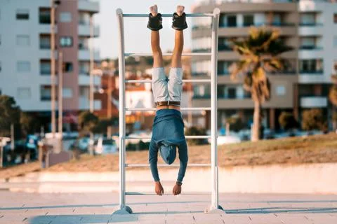 Man hanging upside down on the horizontal bar in anti gravity or inversion boots Stock Photos
