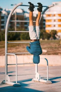 Man hanging upside down on the horizontal bar in anti gravity or inversion boots Stock Photos