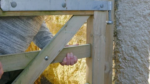Man hanging a yard / garden gate. Stock Footage 129199041