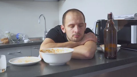 Man with a hangover at the table in the kitchen. after party Video stock 112989533