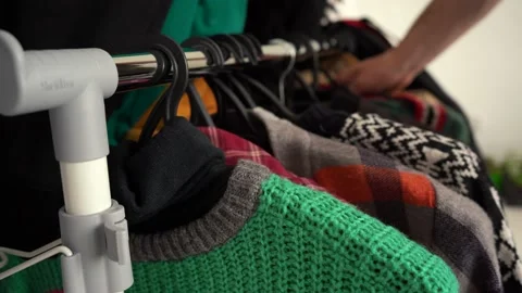 A man hangs clothes on a ram and takes another Stock Footage 154473290