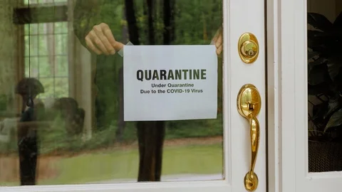 Man hangs Covid-19 virus self quarantine coronavirus sign in window. Stock Footage 127916388