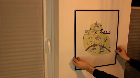 A man hangs a picture Vídeos de archivo 86571951