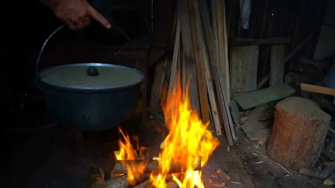 Man hangs up a pot over a fire to make a cabbage soup Stock-Footage 94234318