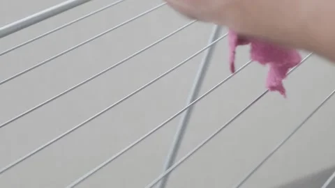 Man hangs rag on dryer and fixes it with clothespin 库存影片 271071108