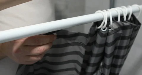 Man hangs a shower curtain Stock Footage 103353541