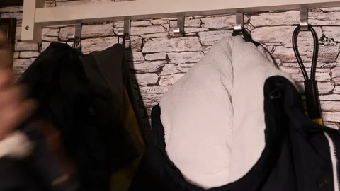 The man hangs a warm jacket on a hanger. hand close up Stock Footage 121497449