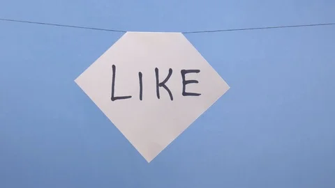 A man hangs a white sheet of paper with a black inscription like on a blue Stock Footage 123786346