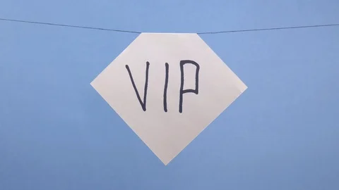 A man hangs a white sheet of paper with a black inscription vip on a blue Stock Footage 123786698