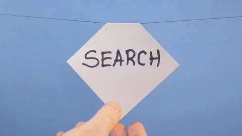 A man hangs a white sheet of paper with a black inscription "search" on a blue Stock-Footage 124588786