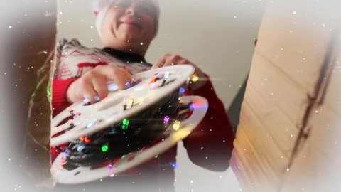 Man is happy about received parcel with spool of garland. Holiday background. Stock Footage 255461069