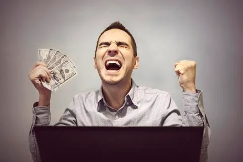 Man is happy in front of the computer to hold 500 dollars Foto stock