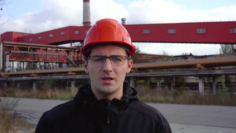 Man in a hard hat stands in the background of the factory Video stock 149780242
