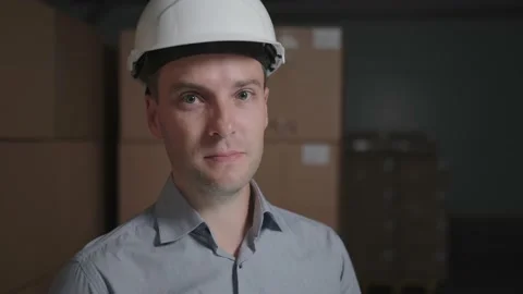 Man in a hard hat in a warehouse on the background of cardboard boxes Video stock 140626829