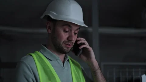 Man in Hardhat Calling for Help in Dark Server Room with Flashing Red Alert Stock-Footage 297167524