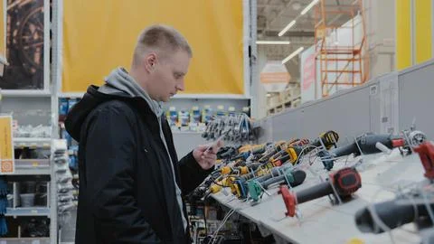 A man in a hardware store chooses electrical goods. The buyer in the store Stock Photos