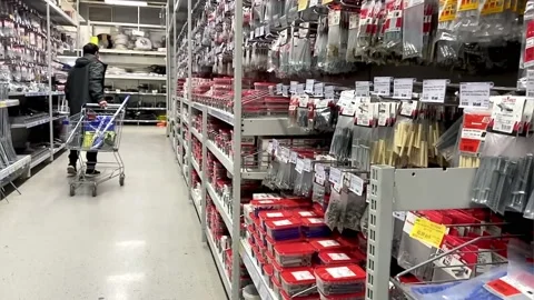 A man in a hardware store with a trolley selects a product.Building materials Stock Footage 160606884