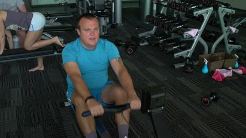 A man has been rowing Simulator in the gym Stock Footage 91588730