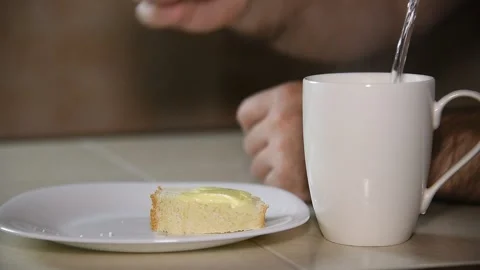 A man has breakfast eats a sandwich washed down with coffee. Stock Footage 145143229