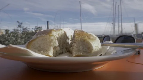 Man has a cafe break and bites into a cinnamon bun Stock Footage 96889522