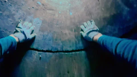 A man has fallen into a well and is feeling the walls of the well in a panic. Stock Footage 319428595
