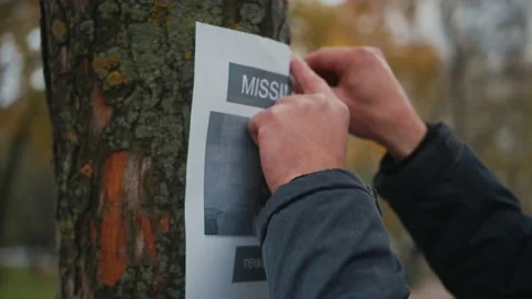 The man has lost his best friend a husky puppy. The owner posts an ad banner Stock Footage 143976072