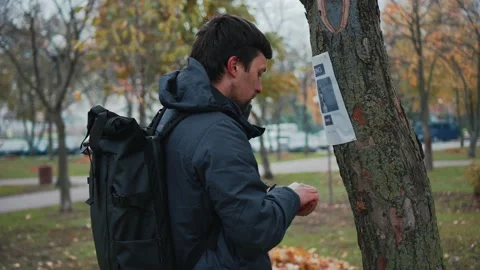 The man has lost his best friend a husky puppy. The owner posts an ad banner Stock Footage 143977209