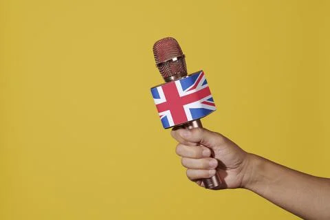 Man has a microphone patterned with the flag of UK Stock Photos