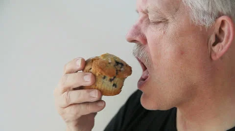 Man has a muffin with coffee Stock Footage 22664643