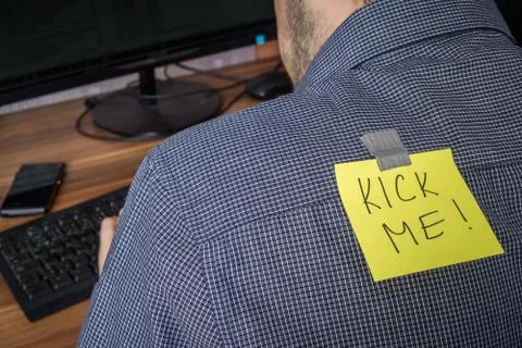 Man has note with Kick me written on it. Joke on first april. Foto stock